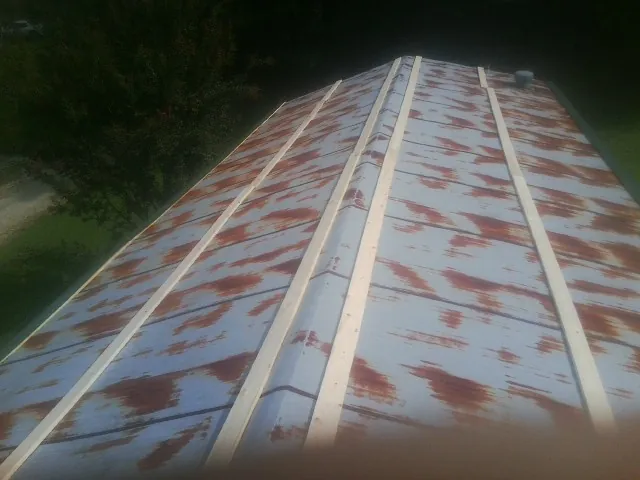 Rusted metal roof panels with new wood purlins before replacement — Storm Damage Roof Repair in Thicket by Roofing Brothers